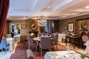 a dining room with tables and chairs and a chandelier at The Residence in Johannesburg