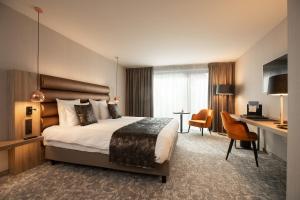 Rúm í herbergi á Hotel Restaurant Van Der Valk Nivelles-Sud