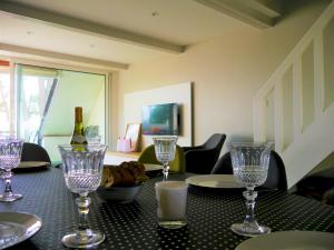 a table with a bottle of wine and glasses on it at Appartement duplex 5 personnes vue sur le port de la Trinité Sur Mer in La Trinité-sur-Mer