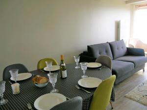 a living room with a table with plates and wine glasses at Appartement duplex 5 personnes vue sur le port de la Trinité Sur Mer in La Trinité-sur-Mer