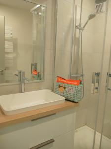 a white bathroom with a sink and a shower at Appartement duplex 5 personnes vue sur le port de la Trinité Sur Mer in La Trinité-sur-Mer