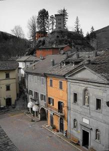 um grupo de edifícios numa colina com uma torre em Torre Riva Dimora storica em Fiumalbo