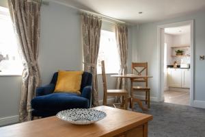 a living room with a blue couch and a table at Beresford Dale in Ashbourne
