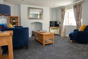 a living room with a blue couch and a table at Beresford Dale in Ashbourne