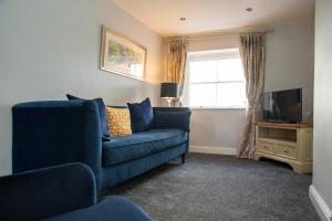 a living room with a blue couch and a television at Manifold Dale in Ashbourne