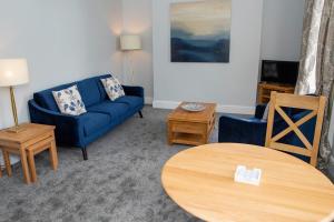 a living room with a blue couch and a table at Milldale in Ashbourne