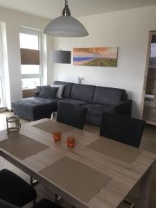 ein Wohnzimmer mit einem blauen Sofa und einem Tisch in der Unterkunft Residenz Bollwark Port Olpenitz in Kappeln