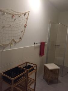 La salle de bains est pourvue d'une douche, de toilettes et d'un tabouret. dans l'établissement Residenz Bollwark Port Olpenitz, à Kappeln