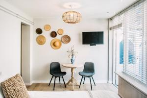 a living room with a table and chairs and a tv at West 7 in Zandvoort