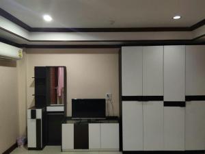 a living room with a television and a room with a wall at Tree House Chachoengsao in Chachoengsao