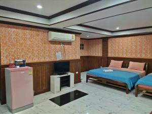 a room with two beds and a television in it at Tree House Chachoengsao in Chachoengsao