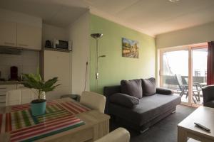 - un salon avec un canapé et une table dans l'établissement Hermes Appartementen, à Berg en Terblijt