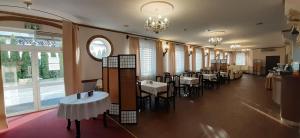 a dining room with tables and chairs and windows at Hotel TWIERDZA in Rzeszów
