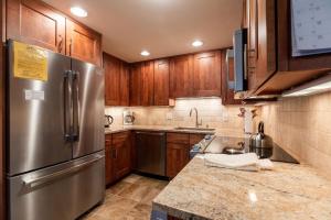 uma cozinha com armários de madeira e um frigorífico de aço inoxidável em All Seasons by Vail Realty em Vail