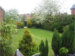 a garden with a lawn with trees and bushes at Baytrees Hotel in Southport