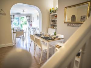 a dining room with a table and chairs and a mirror at Baytrees Hotel in Southport