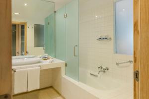 a bathroom with a tub and a sink and a shower at The Albatroz Hotel in Cascais