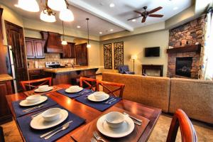 a dining room with a wooden table and a couch at Canyon Villas at Coral Ridge in Washington