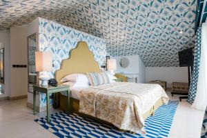 a bedroom with a bed and a blue and white wallpaper at The Albatroz Hotel in Cascais