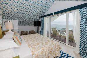 a bedroom with a bed and a balcony with the ocean at The Albatroz Hotel in Cascais