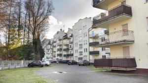 a parking lot with cars parked in front of buildings at VacationClub - Gryfa Pomorskiego 77D Apartament 34B in Międzyzdroje +1 photo