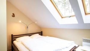 a bedroom with a bed in a attic at VacationClub - Gryfa Pomorskiego 77D Apartament 34B in Międzyzdroje