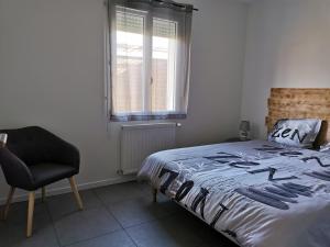 a bedroom with a bed and a chair and a window at Maison neuve 66m2 Biscarrosse in Biscarrosse