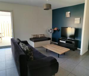 ein Wohnzimmer mit einem Sofa und einem Couchtisch in der Unterkunft Maison neuve 66m2 Biscarrosse in Biscarrosse
