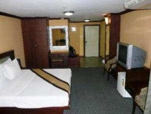 a hotel room with a bed and a television at King Royal Garden Inn in Bangkok +16 photos