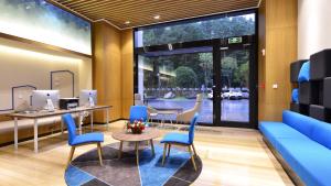 a waiting room with blue chairs and a blue couch at Holiday Inn Express Luanchuan by IHG in Luanchuan