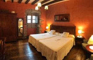 1 dormitorio con 2 camas en una habitación con paredes rojas en Casa Rural Zigako Etxezuria en Ziga