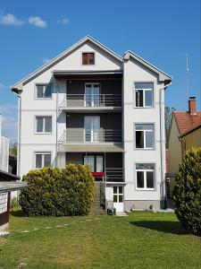 a white apartment building with a green yard at Villa Ponte in Pančevo