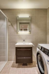 a bathroom with a sink and a washing machine at Trondheim Leilighetshotel in Trondheim