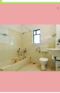 a bathroom with a tub and a toilet and a sink at Tranquil Dreams in Kārli