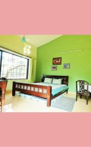 a bedroom with a bed and a green wall at Tranquil Dreams in Kārli +6 photos