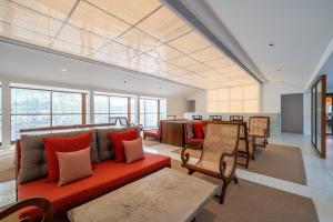a living room with a red couch and chairs at Cinnamon Bentota Beach - Signature Selection in Bentota