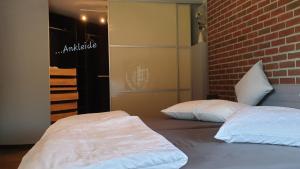 - 2 lits dans une chambre avec un mur en briques dans l'établissement Ferienwohnung Sofia, à Papenbourg