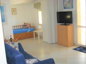 ein Wohnzimmer mit einem Sofa und einem TV in der Unterkunft Gambusia in Scoglitti