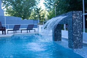 a water fountain in a pool with two benches at La Divina Pereza in San Rafael