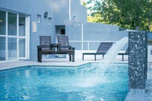 a fountain in a swimming pool with two chairs at La Divina Pereza in San Rafael