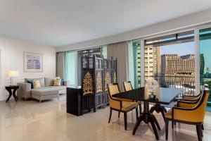 a living room with a table and chairs and a couch at Dusit Suites Hotel Ratchadamri, Bangkok in Bangkok