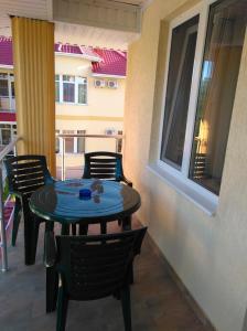 a patio with a table and chairs on a balcony at Mini-Dacha in Kurortne