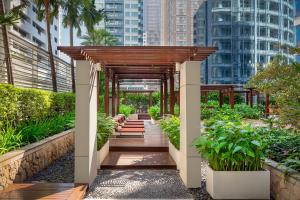 a wooden walkway in a city with tall buildings at Dusit Suites Hotel Ratchadamri, Bangkok in Bangkok