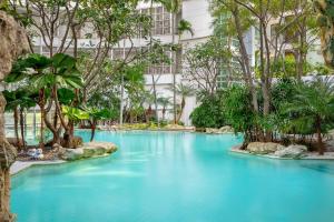 a pool in the middle of a building with blue water at Dusit Suites Hotel Ratchadamri, Bangkok in Bangkok