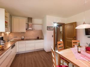 斯圖姆的住宿－Ferienwohnung Huber，厨房配有白色橱柜和木桌