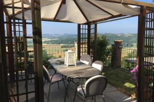 a patio with a table and chairs and an umbrella at La Fiaba del Monferrato in Vignale Monferrato