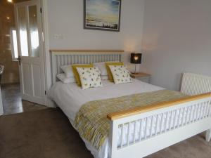 溫特爾頓海濱的住宿－Moonfleet House，一间卧室配有白色床和黄色枕头
