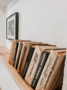 una fila de libros sentados en un estante en 2 Baloži en Kuldīga