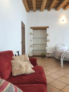 a living room with a red couch and a bedroom at Ai Leoni in Verona