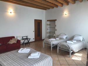 sala de estar con 2 camas y sofá rojo en Ai Leoni, en Verona